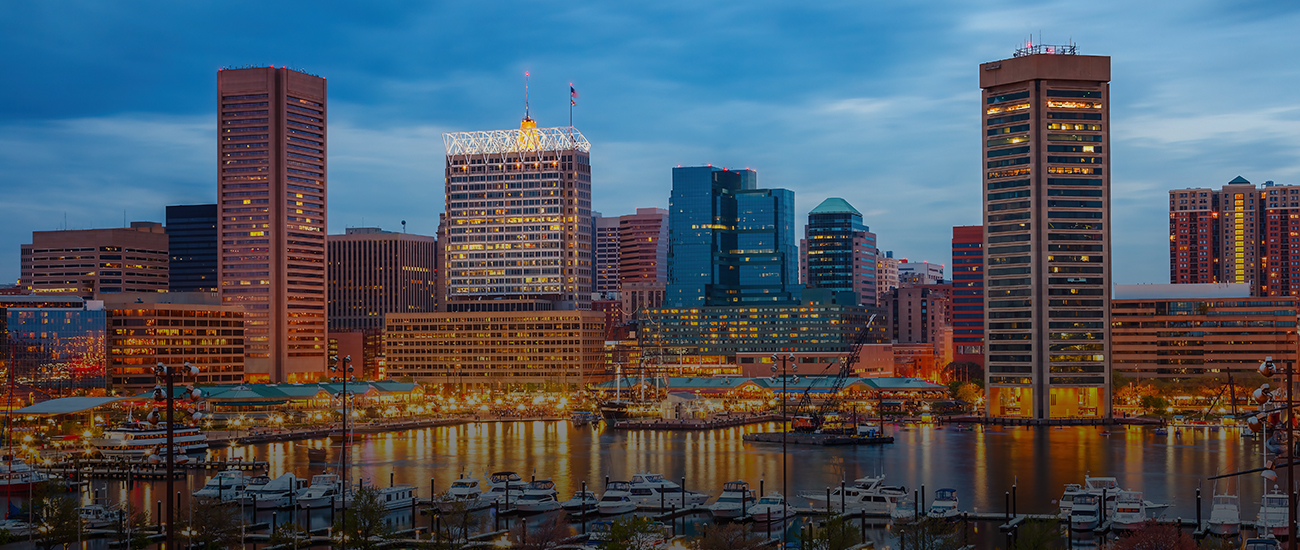 A picturesque city skyline at dusk, featuring a blend of lights and shadows under a fading sunset